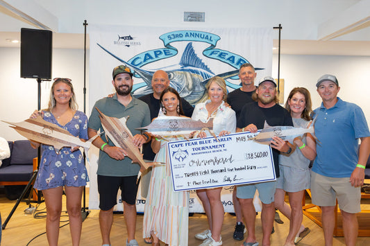 Team OUTNUMBERED holds the $28,560 1st Place Level One winner check on stage at the 53rd Annual Cape Fear Blue Marlin Tournament awards party, Wrightsville Beach NC, May 30 2026.