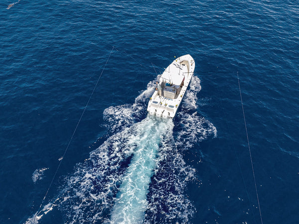 Offshore trolling spread with rigged ballyhoo and skirted lures set behind the transom — color, size, and head shape matched to target species. Credit: Salt Water Sportsman