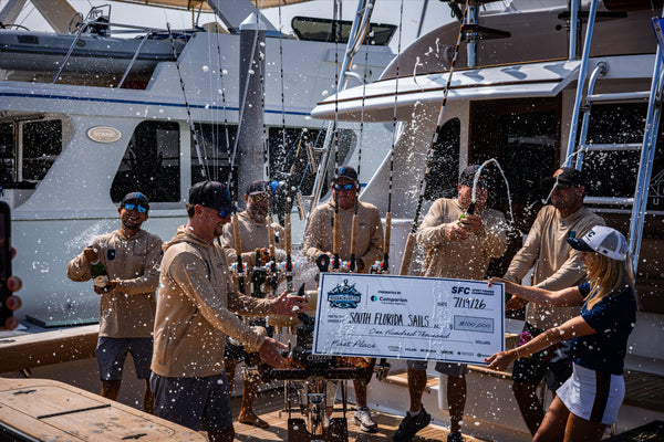 The South Florida Sails crew spray champagne with the SFC first-place check after winning the 2026 SFC Cape Cod Invitational at MacDougall's Marina. Photo: McKettrick / Sport Fishing Championship.