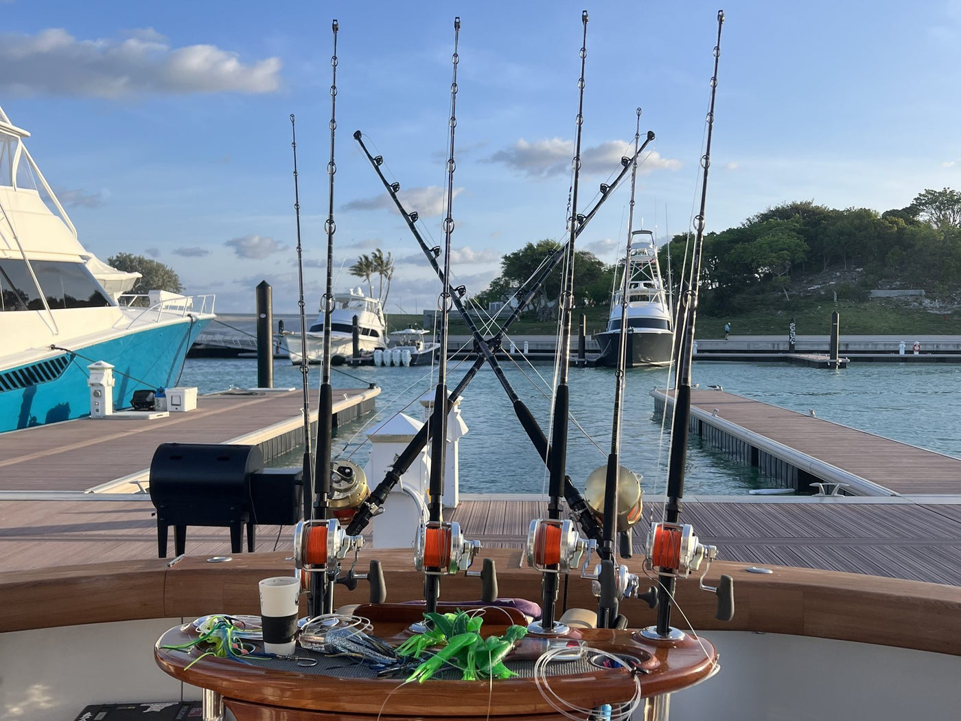 Mark's wooden rigging table — offshore reels, lures, rods on the cockpit at the marina